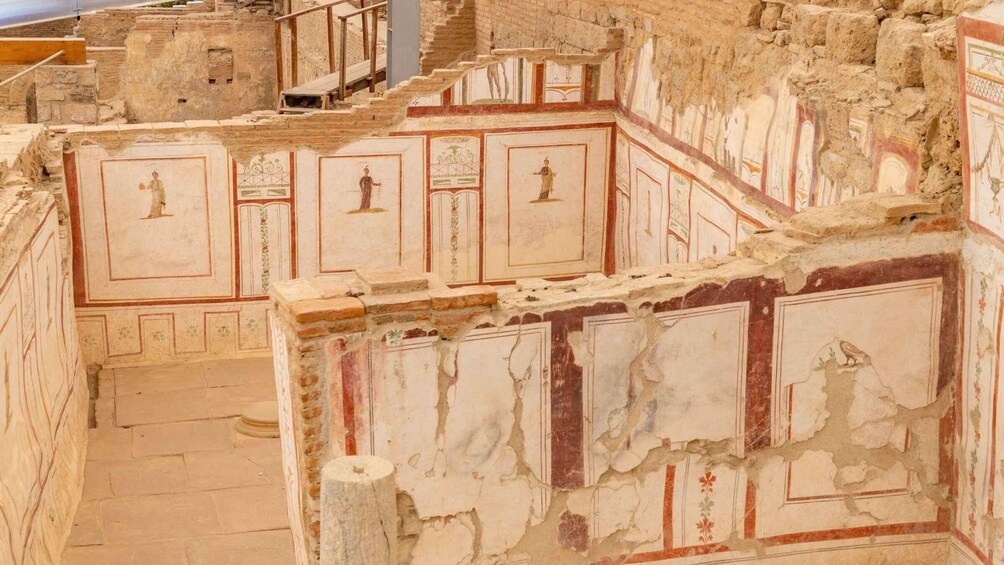Ancient ruins with frescoes depicting figures and architectural details. 3