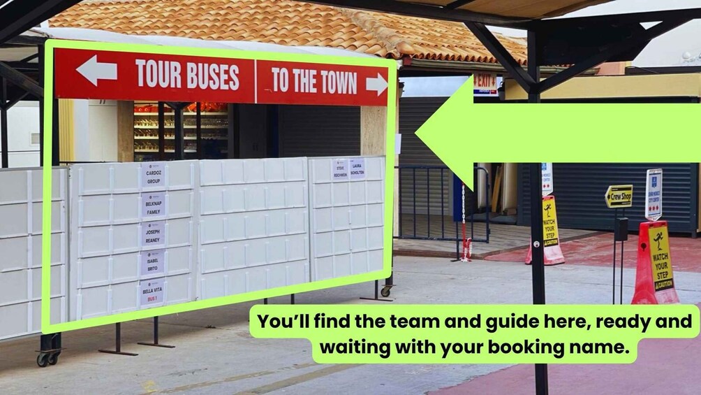 A bus station with signs for 'TOUR BUSES' and 'TO THE TOWN'. There is a large whiteboard with names on it, and a sign that says 'Crew Shop'. 4