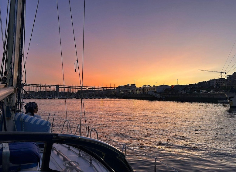 A sunset over a harbor with a bridge and buildings in the background. 1