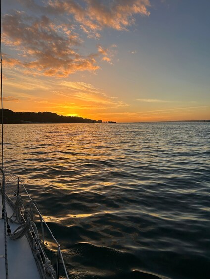A sunset over a calm sea with a boat in the foreground. 2