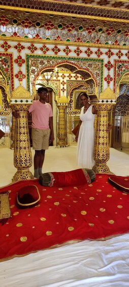 A richly decorated interior with ornate columns and a red carpet. 1