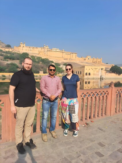 Three people standing in front of a historic fort. 5