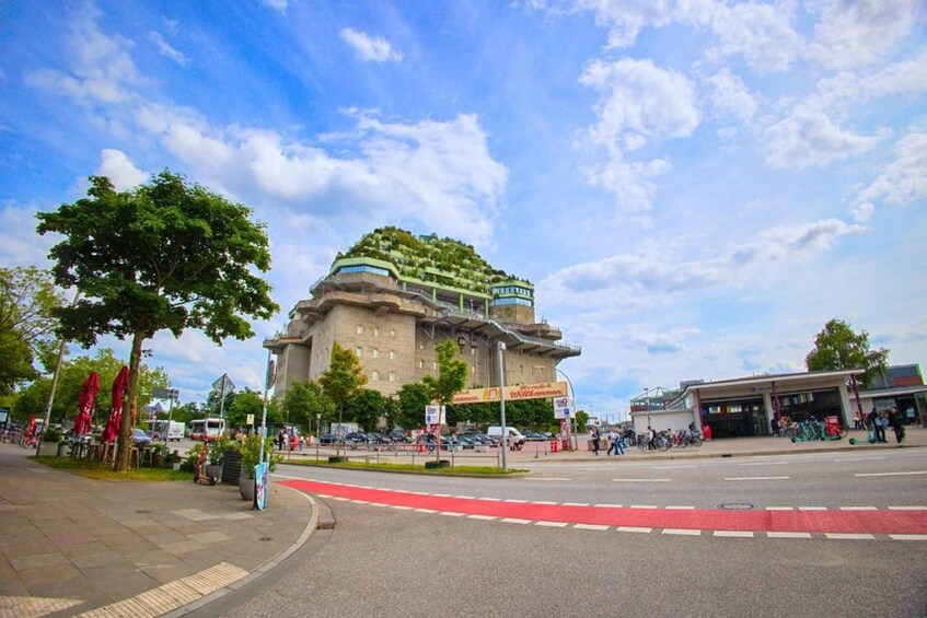 A large building with a green roof and a red bike lane in front. 4