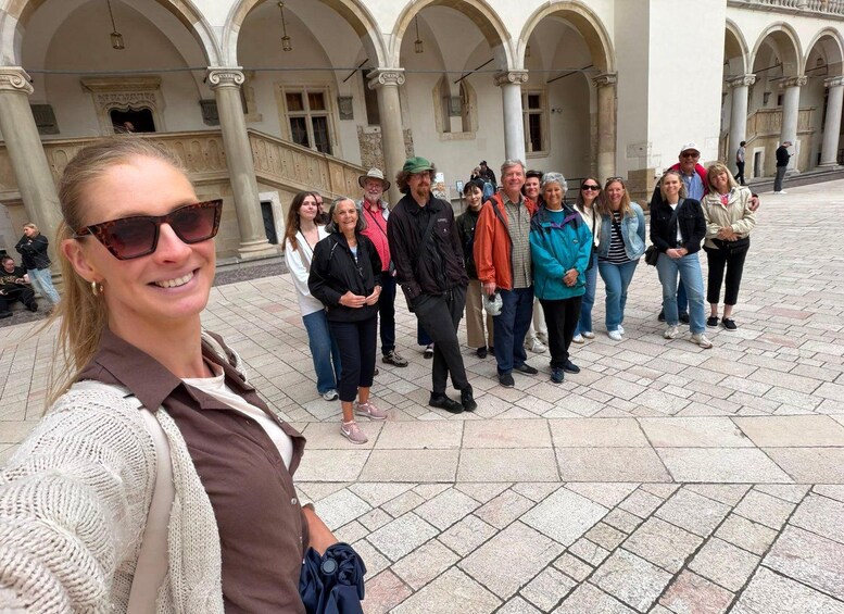 A group of people standing in a courtyard with arches and columns. 5
