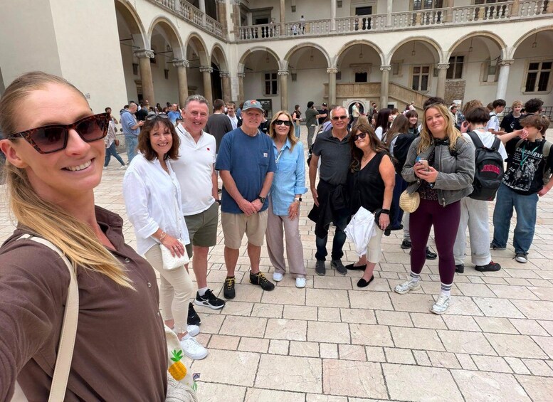 A group of people standing in a courtyard with arches and columns. 4