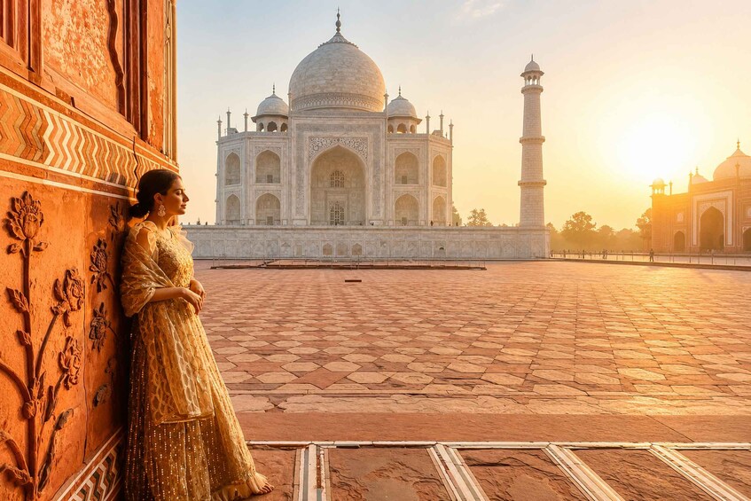 A person in traditional attire standing in front of the Taj Mahal. 2