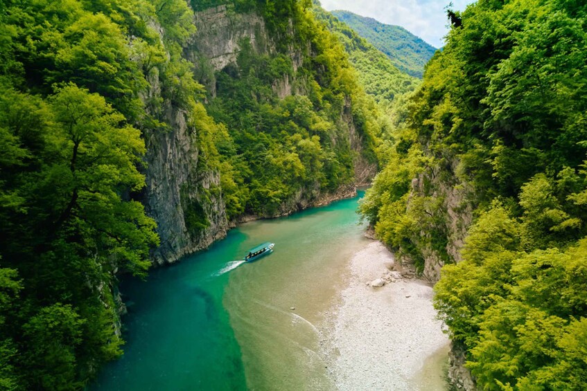 A river winding through a canyon with dense green foliage on both sides. 1