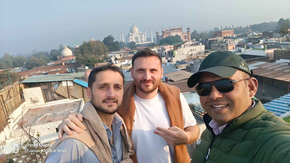 Three people taking a selfie with the Taj Mahal in the background. 5