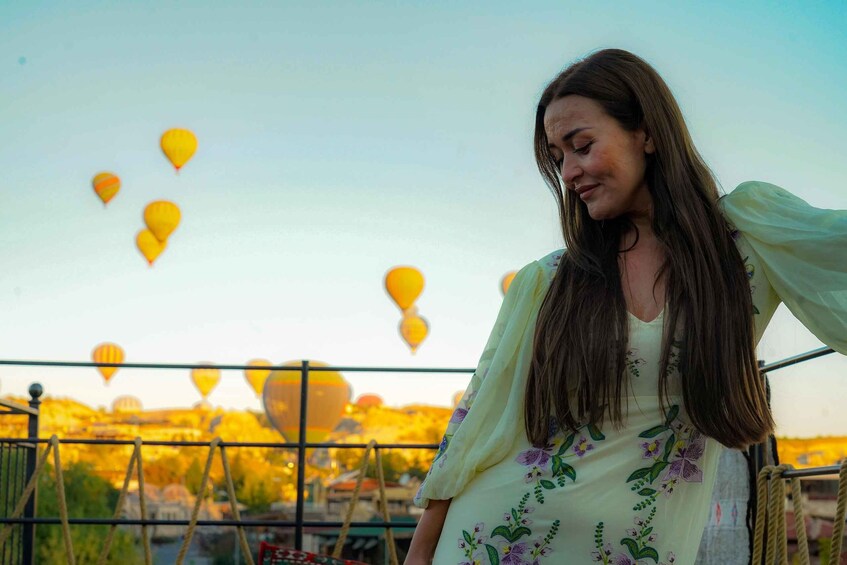 A person standing with a view of hot air balloons in the background. 2