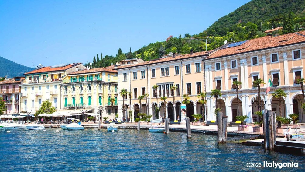 A waterfront with colorful buildings, a clear blue sky, and boats docked along the water. 1