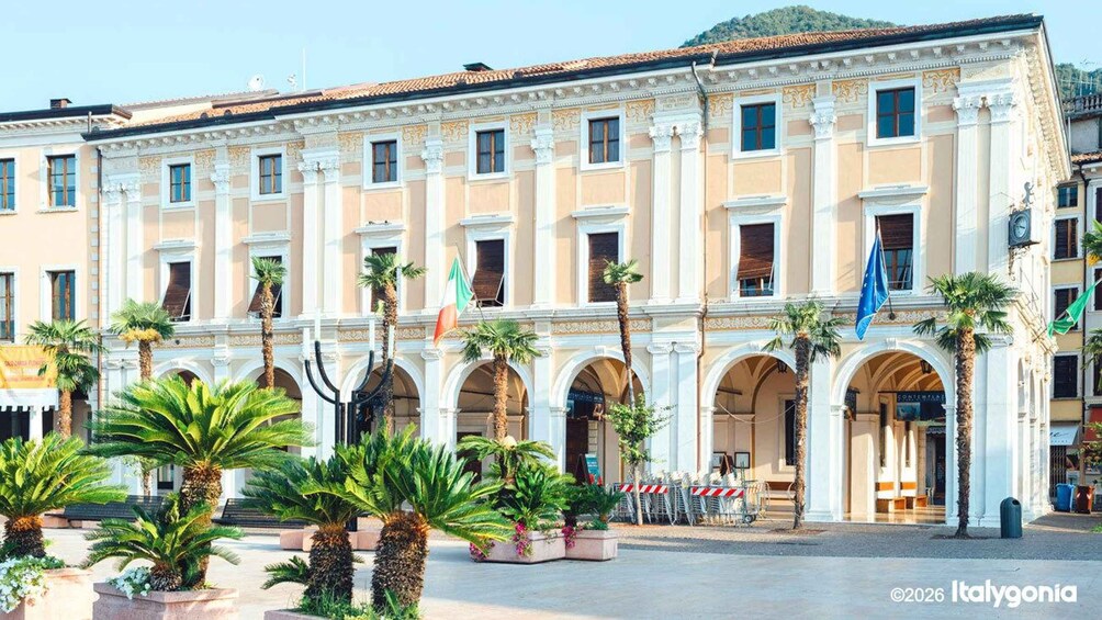 A historic building with classical architecture, palm trees, and flags. 3