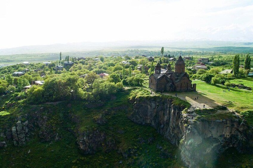 A church on a cliff overlooking a village. 4