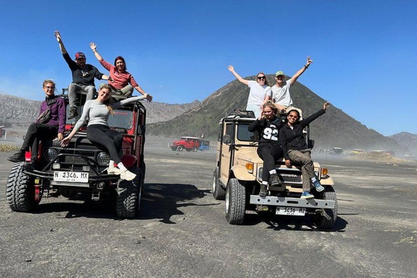 Cuatro personas en un buggy y un jeep en un paisaje desértico con montañas al fondo. 3