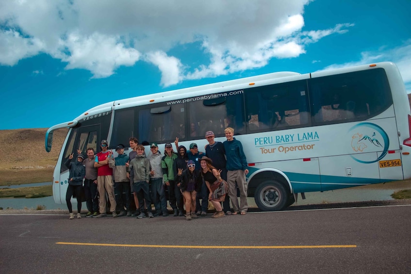A group of people posing in front of a tour bus with the text "Peru Baby Lama Tour Operator" on its side. 2