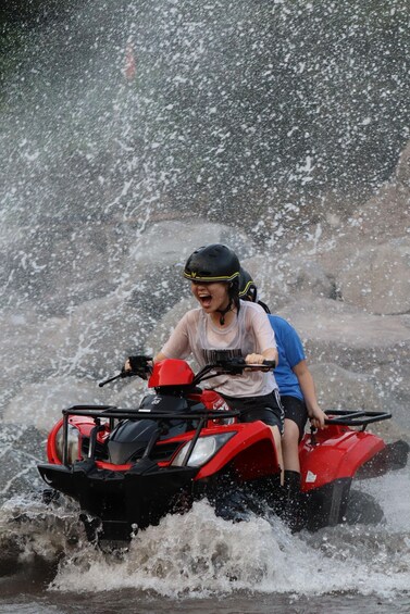 Una persona guida un quad rosso in acqua. 4