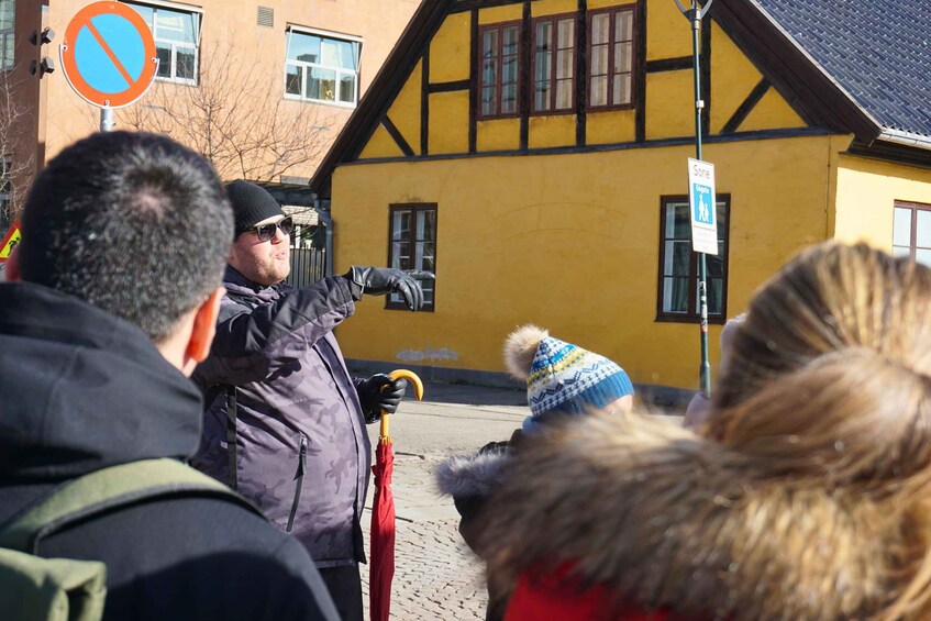 A group of people standing in front of a yellow building with a 'Sone' sign. 5