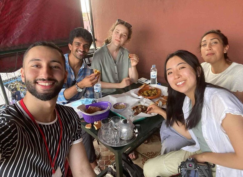 A group of people sitting at a table with food and drinks. 5