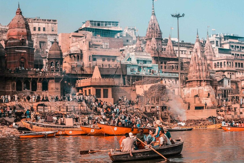A crowded riverside with boats and people. 1