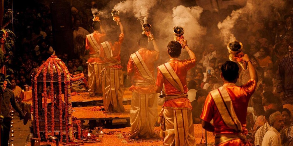 A group of people in traditional attire performing a ritual with incense and offerings. 5
