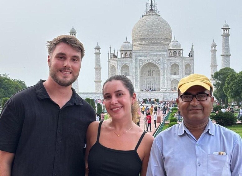 Three people standing in front of the Taj Mahal. 2