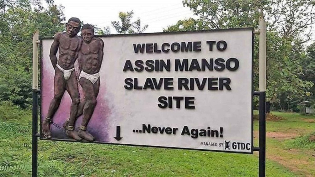Et skilt, der byder besøgende velkommen til Assin Manso Slave River Site med budskabet 'Never Again!', administreret af GTDC. 2