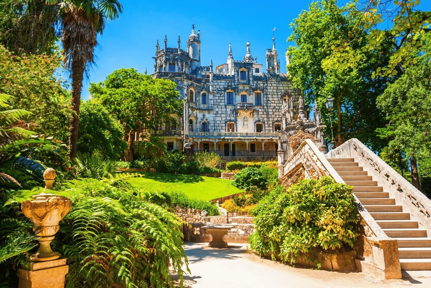 A grand, ornate castle surrounded by lush greenery and a well-maintained garden. 2