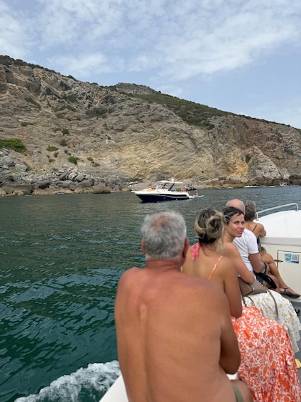 A boat with passengers on a rocky coastline. 4