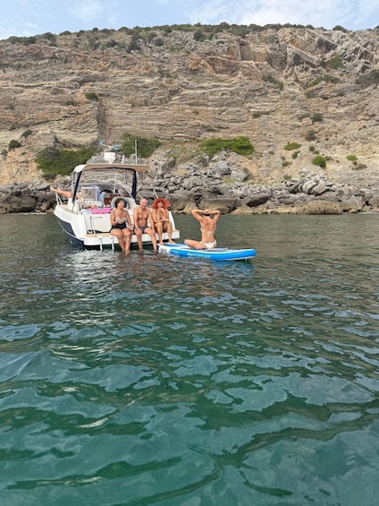 A boat with people on a rocky coastline. 2