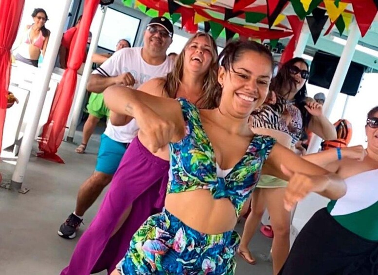 A group of people dancing outdoors under colorful flags. 4
