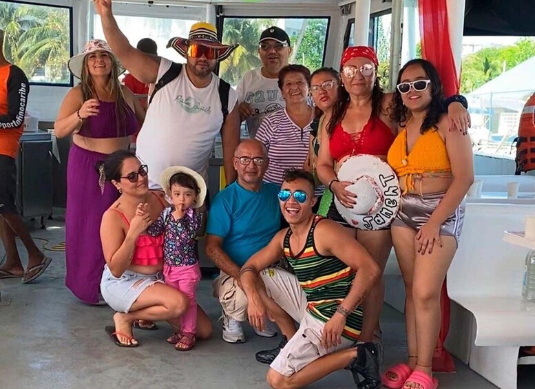 A group of people posing for a photo on a boat deck. 1