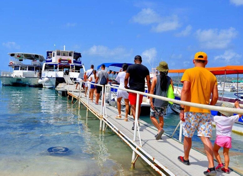 A pier with people walking towards boats. 2