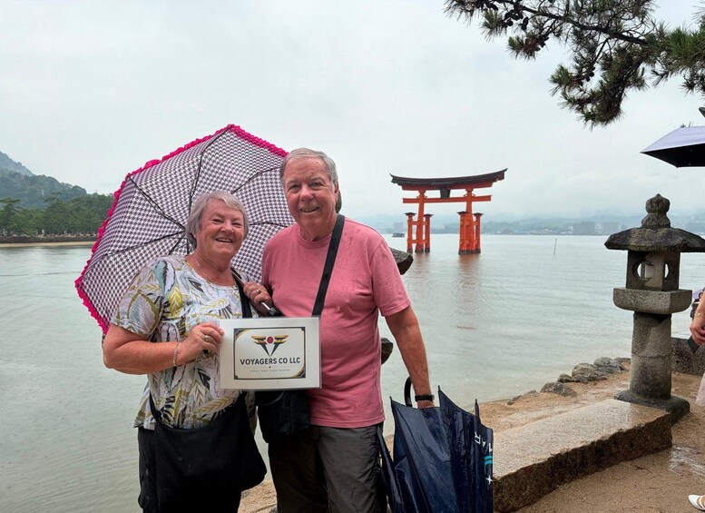 Two people standing by a body of water with a traditional Japanese torii gate in the background. 3
