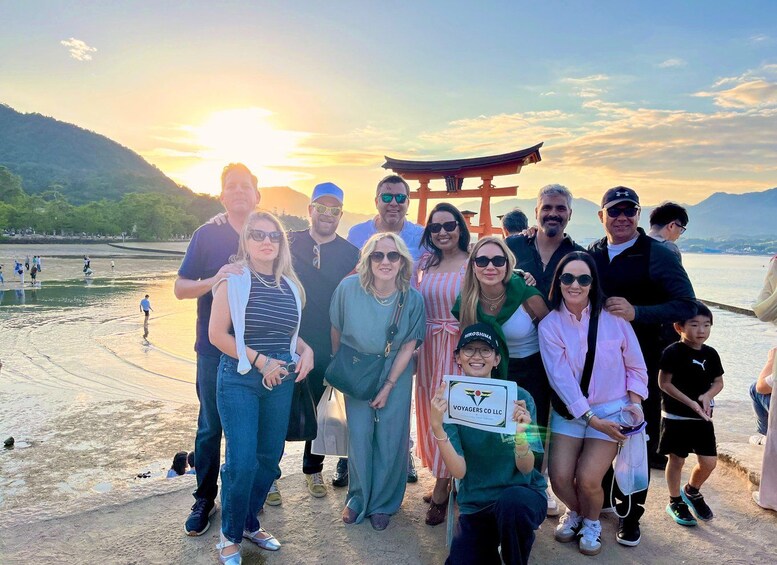 A group of people at a coastal location with a traditional Japanese torii gate in the background. 5