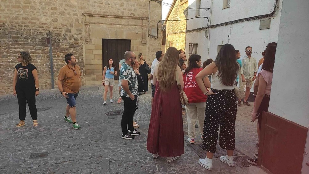 A group of people standing on a cobblestone street in a historic town. 5
