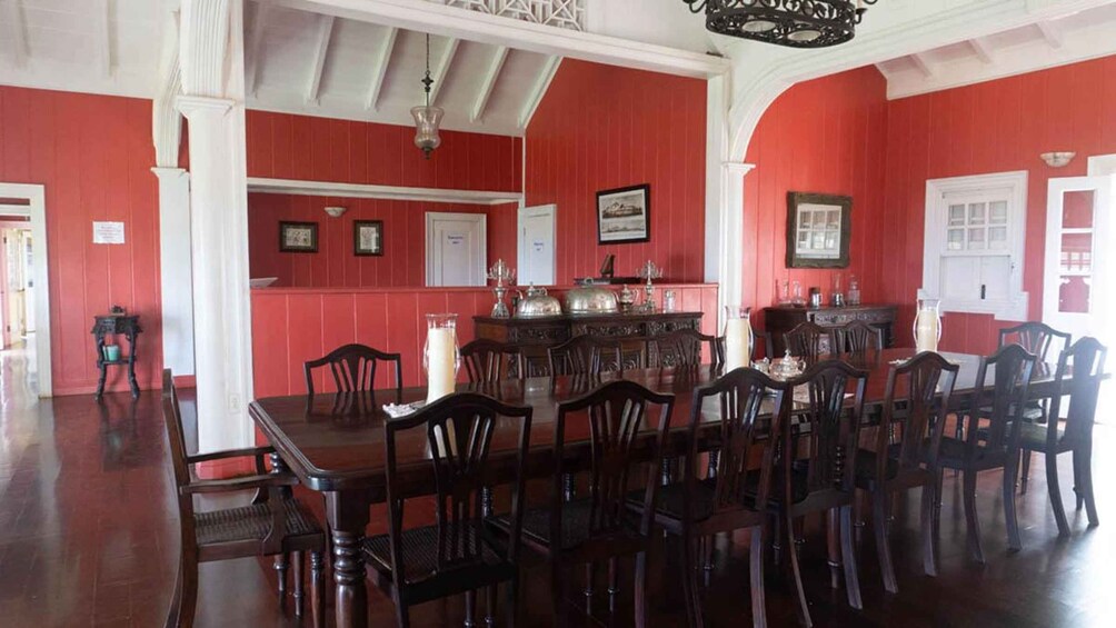 A dining room with red walls, white trim, and wooden furniture. 5