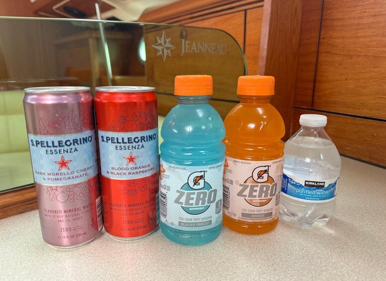 Four beverage cans and bottles on a countertop. 2