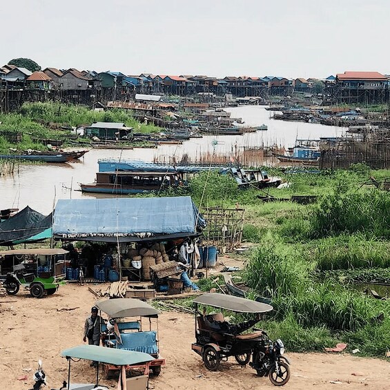 A riverside settlement with boats, makeshift stalls, and a mix of wooden and metal structures. 3