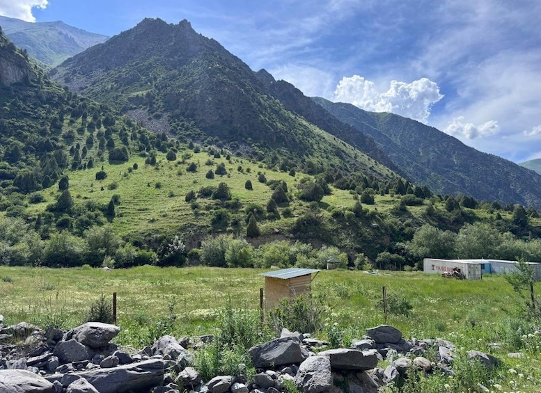 A mountainous landscape with a small wooden structure and a metal shed. 3
