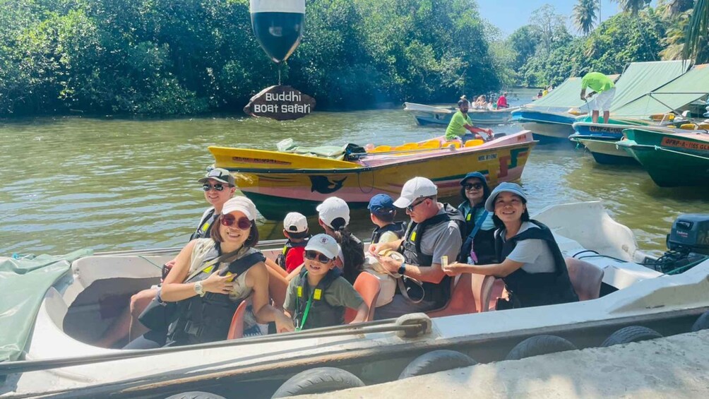 A group of people on a boat with a sign reading "Budhli Boat Safari". 4