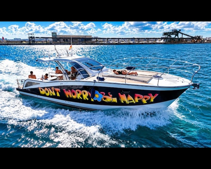 A speedboat with colorful text on its side, moving through a body of water with a bridge in the background. 5