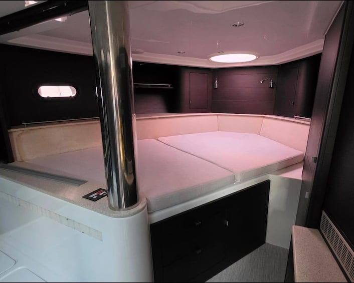 A compact, well-lit interior with a bed, storage compartments, and a small window. 3