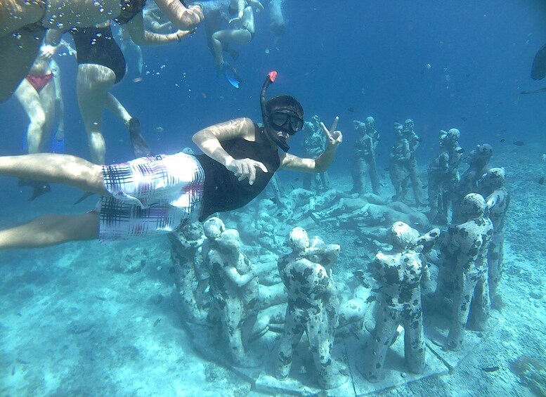 A person snorkeling among underwater ruins. 1