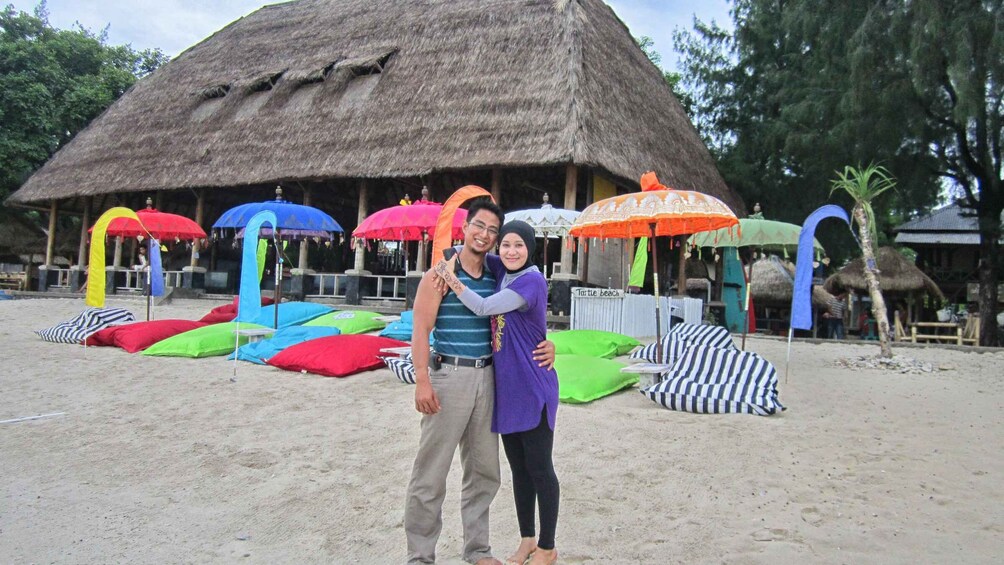A beach with a thatched-roof hut, colorful umbrellas, and striped beach chairs. 2