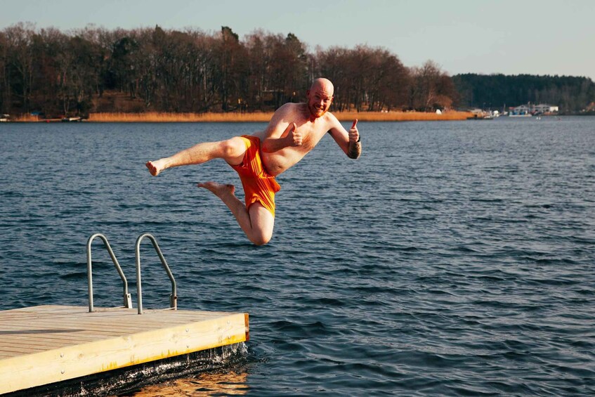 A man jumping off a dock into a lake. 5