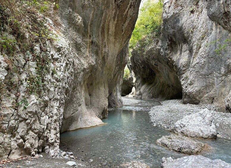 A narrow canyon with a river flowing through it. 5