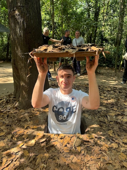 A person holding a large piece of cardboard with leaves on it. 1