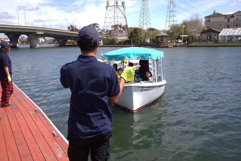 A boat docked at a pier with a bridge in the background. 5