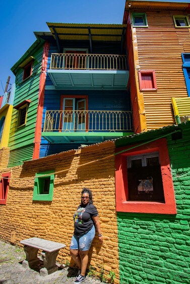 A colorful building with a balcony and a person standing in front. 4
