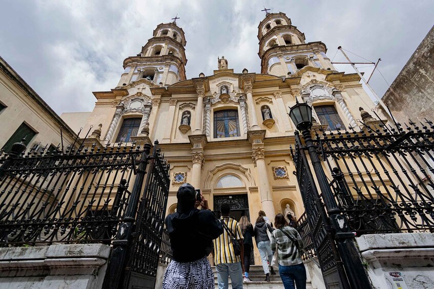 A historic church with ornate architecture and a black iron gate. 5