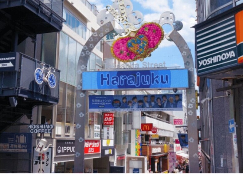 A street sign for Harajuku with a decorative arch above it. 3
